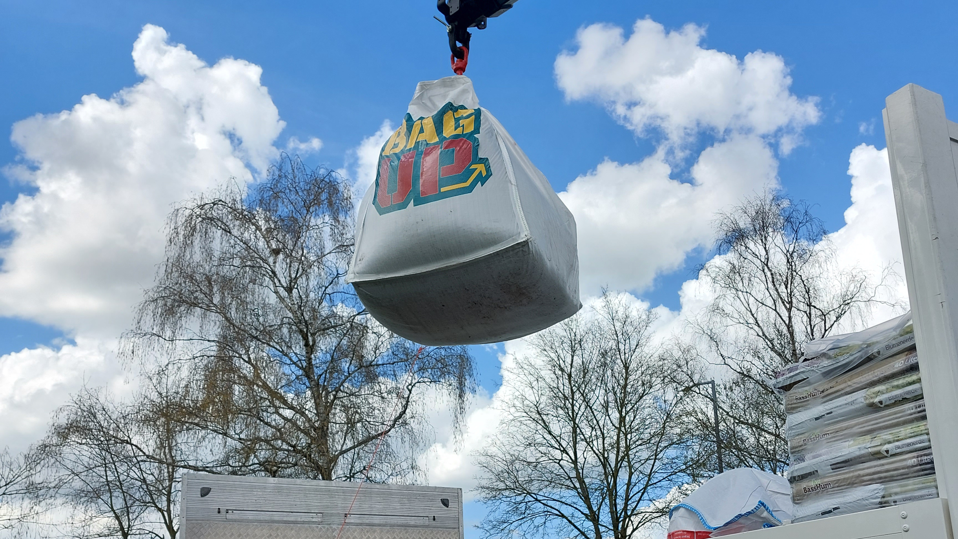 Ein Big-Bag hängt an einem Kran. Darauf ist ein Aufkleber des Logos "BagUp" zu sehen.
