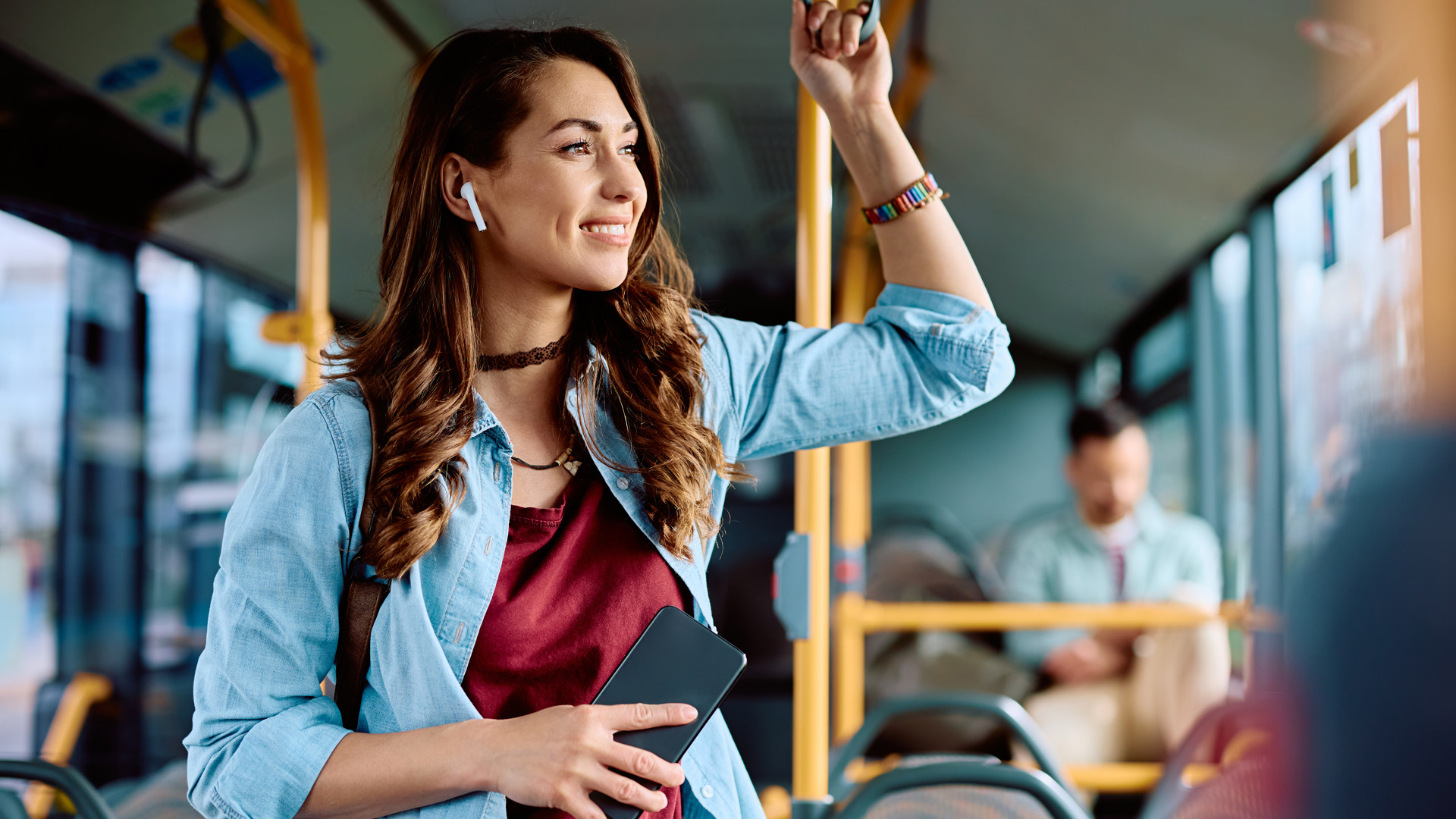 Das Symbolbild einer Frau in einem Bus, die einen Podcast hört.