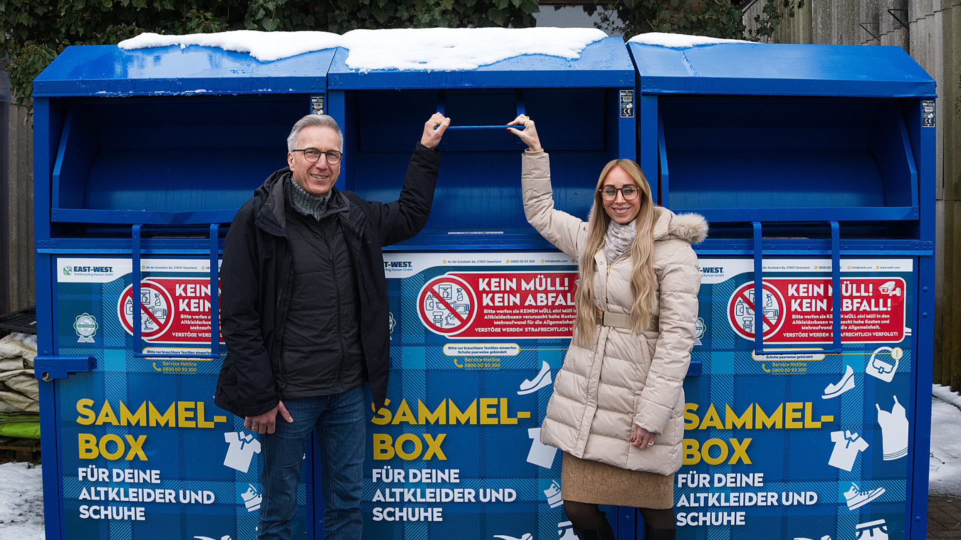 Vertreter des BUEZ und der AWG Bassum stehen an einem Altkleidercontainer.